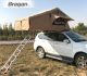 Khaki universal rooftop tent opened for camping with ladder on 4x4
